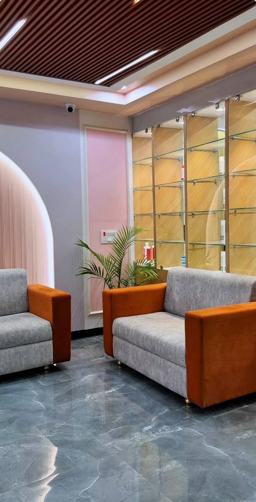 True Aura Family Salon lounge with warm wood-slat ceiling and marble flooring