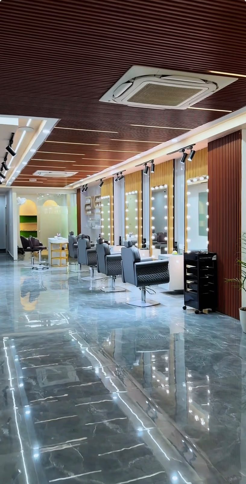True Aura Family Salon styling stations with lit vanity mirrors and marble flooring